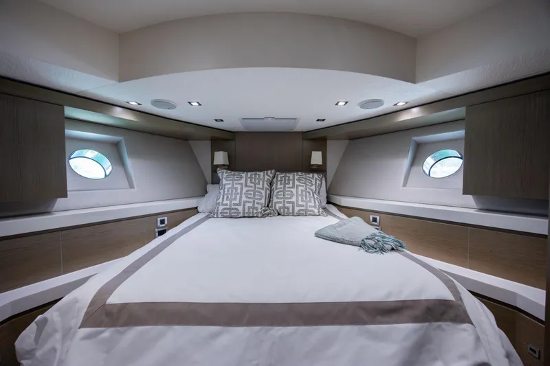 Slide: The Image of Luxurious bedroom interior of 2017 Hatteras M75 Panacera yacht with elegant bedding and porthole windows. - 73