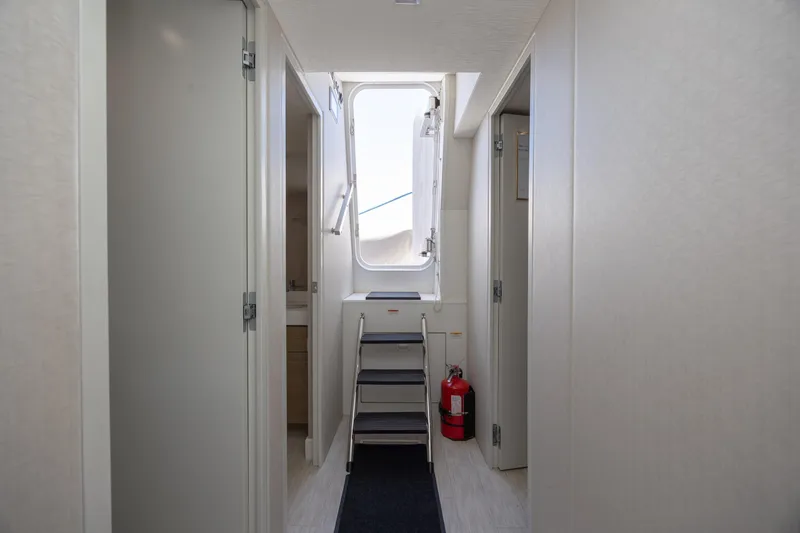 Slide: The Image of Interior hallway of 2017 Hatteras M75 Panacera yacht with stairs and fire extinguisher. - 84