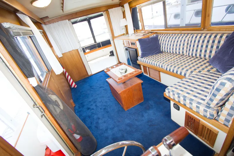 Slide: The Image of Interior of a 1984 Californian LRC yacht with blue carpet and striped sofa. - 7