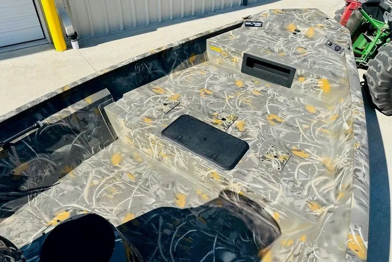 Slide: The Image of 2026 War Eagle 961 Blackhawk boat with camouflage design, parked outdoors. - 6