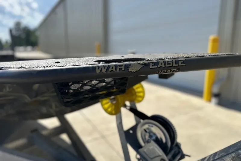 Slide: The Image of 2026 War Eagle 961 Blackhawk boat detail with logo, outdoor setting. - 9
