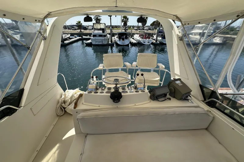 Slide: The Image of 1987 Californian 34 yacht cockpit with marina view, featuring helm controls and seating. - 4