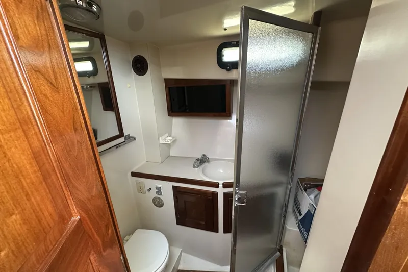 Slide: The Image of Compact bathroom in a 1987 Californian 34 yacht with shower, sink, and toilet. - 9