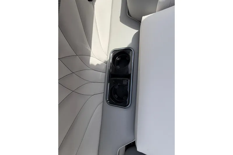 Slide: The Image of 2026 Avalon Excalibur Quad Lounge boat interior with cup holders and elegant stitching. - 12