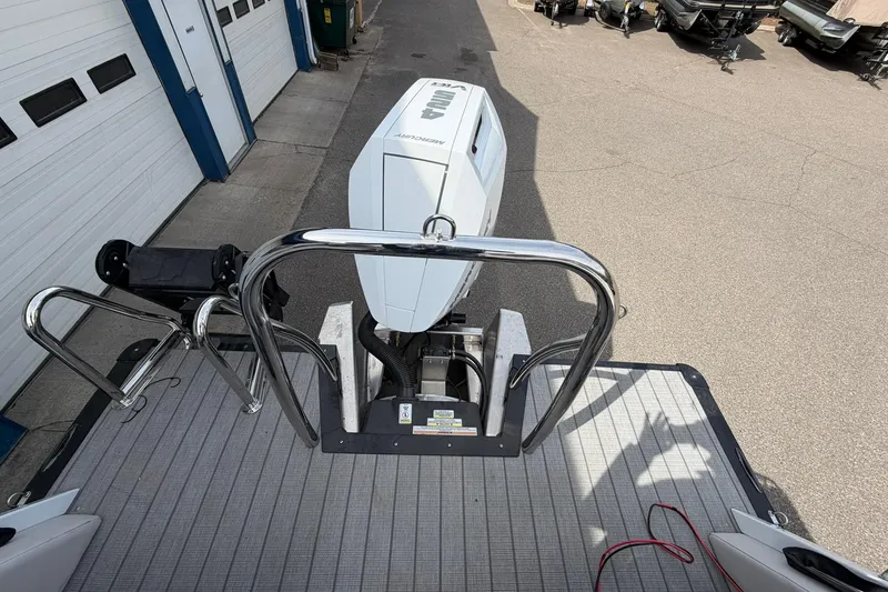 Slide: The Image of 2026 Avalon Excalibur Quad Lounge boat with outboard motor and stainless steel railing. - 21