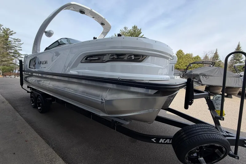 Slide: The Image of 2026 Avalon Excalibur Quad Lounge Windshield boat on trailer, parked outdoors. - 4