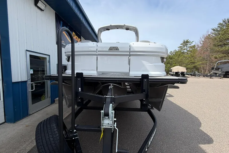 Slide: The Image of 2026 Avalon Excalibur Quad Lounge Windshield boat on trailer, parked outside dealership. - 5