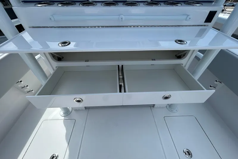 Slide: The Image of 2026 Contender 39 ST boat interior with open storage drawers and rod holders. - 13