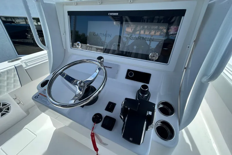 Slide: The Image of 2026 Contender 39 ST boat dashboard with steering wheel and Garmin display. - 14