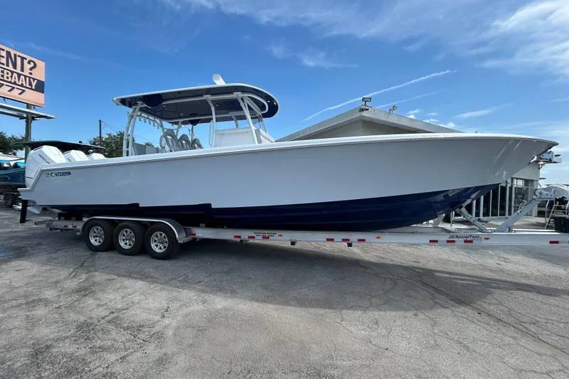 Slide: The Image of 2026 Contender 39 ST boat on trailer, displayed outdoors under clear blue sky. - 6