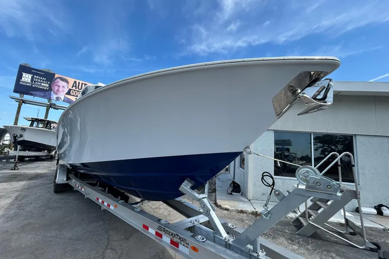 Slide: The Image of 2026 Contender 39 ST boat on trailer, displayed outdoors under a clear blue sky. - 8