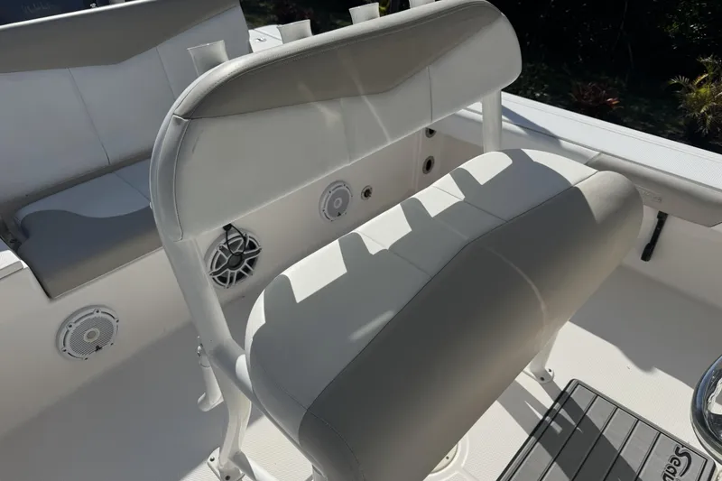 Slide: The Image of 2018 Robalo 226 Cayman boat interior with cushioned seating and built-in speakers. - 11