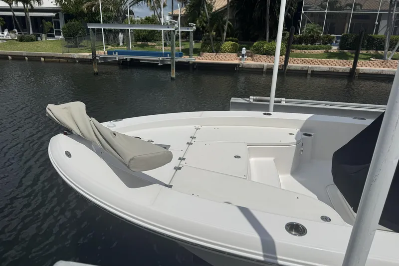 Slide: The Image of 2018 Robalo 226 Cayman boat docked, featuring spacious deck and seating area. - 4