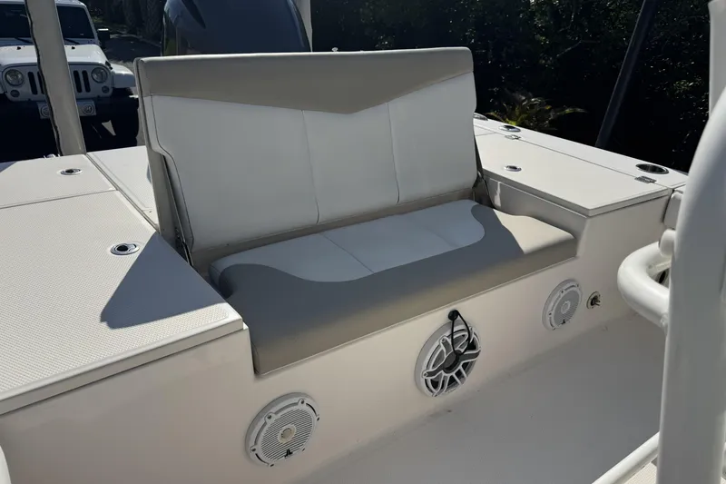Slide: The Image of 2018 Robalo 226 Cayman boat seating area with speakers and storage compartments. - 9