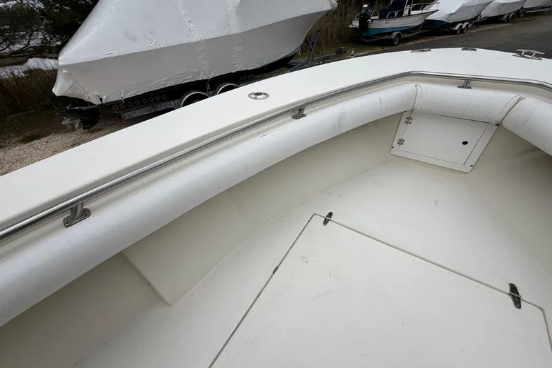 Slide: The Image of 1985 SeaCraft SC 23 Classic boat interior with white cushioned seating and storage compartment. - 13