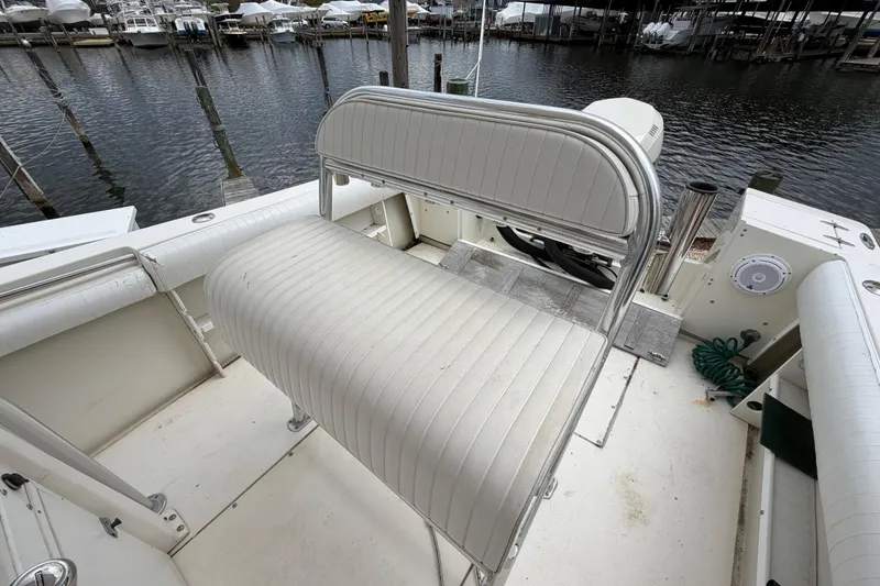 Slide: The Image of 1985 SeaCraft SC 23 Classic boat interior with white seating, docked at a marina. - 25