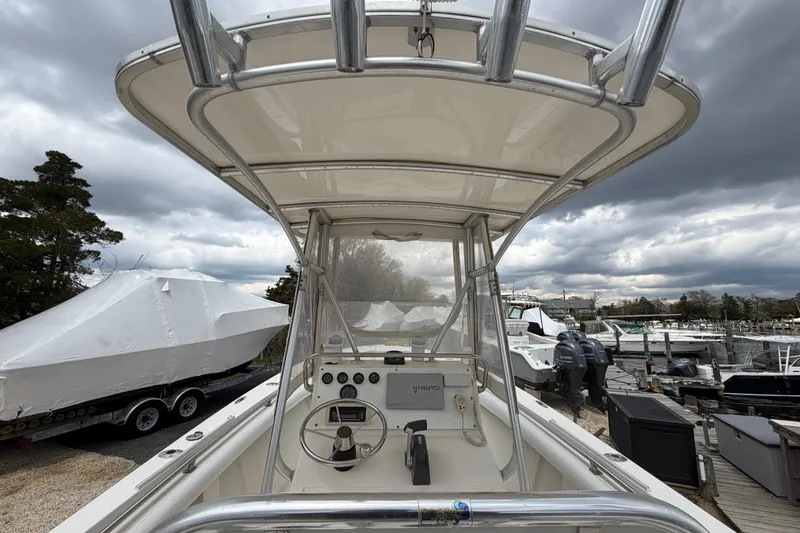 Slide: The Image of 1985 SeaCraft SC 23 Classic boat with T-top, docked under cloudy skies. - 27