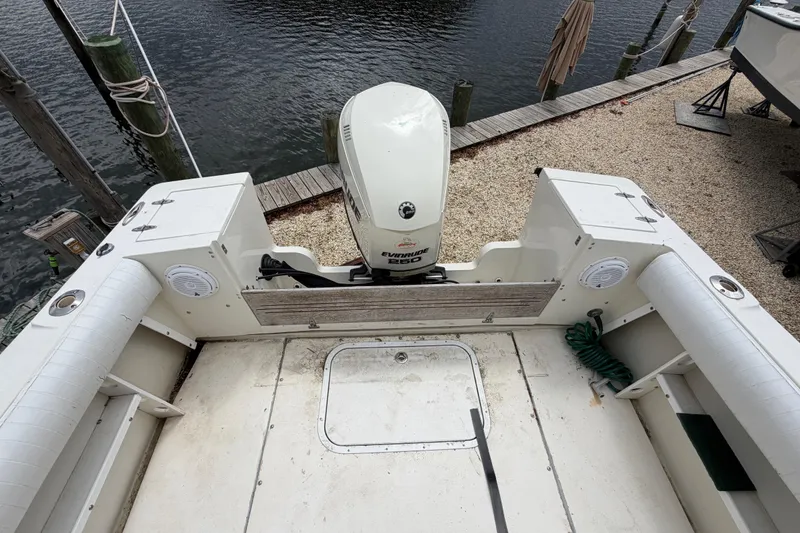 Slide: The Image of 1985 SeaCraft SC 23 Classic boat with Evinrude motor, docked by the water. - 29