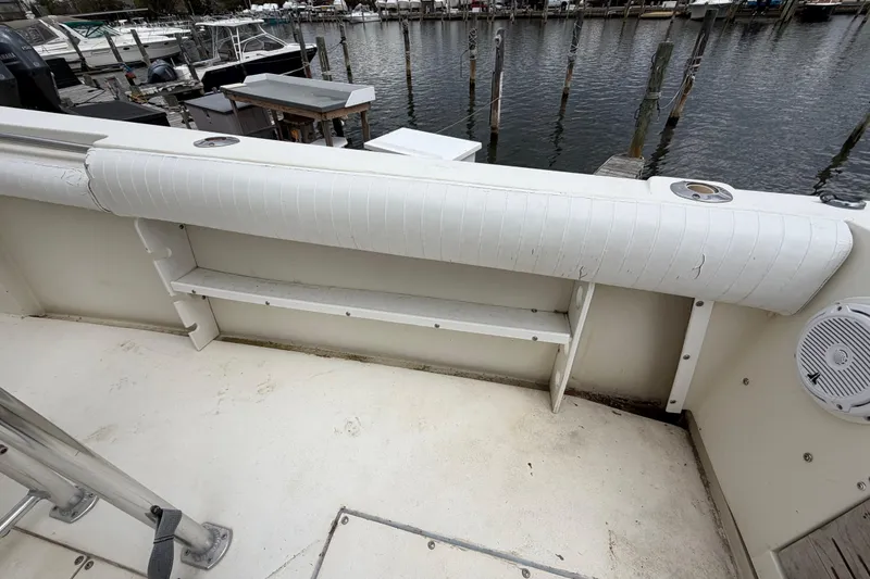 Slide: The Image of 1985 SeaCraft SC 23 Classic boat interior with white seating and storage, docked by the water. - 30