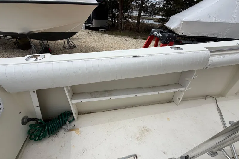 Slide: The Image of 1985 SeaCraft SC 23 Classic boat interior with white cushioned seating and storage area. - 31