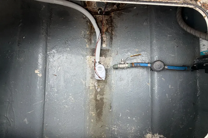 Slide: The Image of Bilge area of a 1985 SeaCraft SC 23 Classic boat, showing wiring and plumbing components. - 32