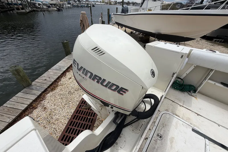 Slide: The Image of 1985 SeaCraft SC 23 Classic boat with Evinrude outboard motor docked by the water. - 35