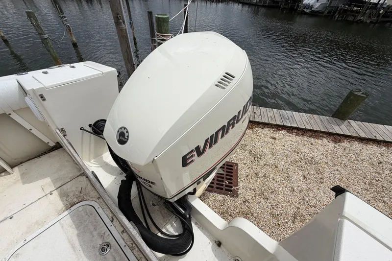 Slide: The Image of 1985 SeaCraft SC 23 Classic boat with Evinrude outboard motor docked by the water. - 36