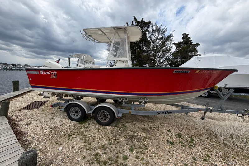 Slide: The Image of 1985 SeaCraft SC 23 Classic boat on trailer, red hull, dockside setting. - 4
