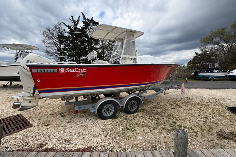 Slide: The Image of Red 1985 SeaCraft SC 23 Classic boat on trailer, parked outdoors under cloudy sky. - 5