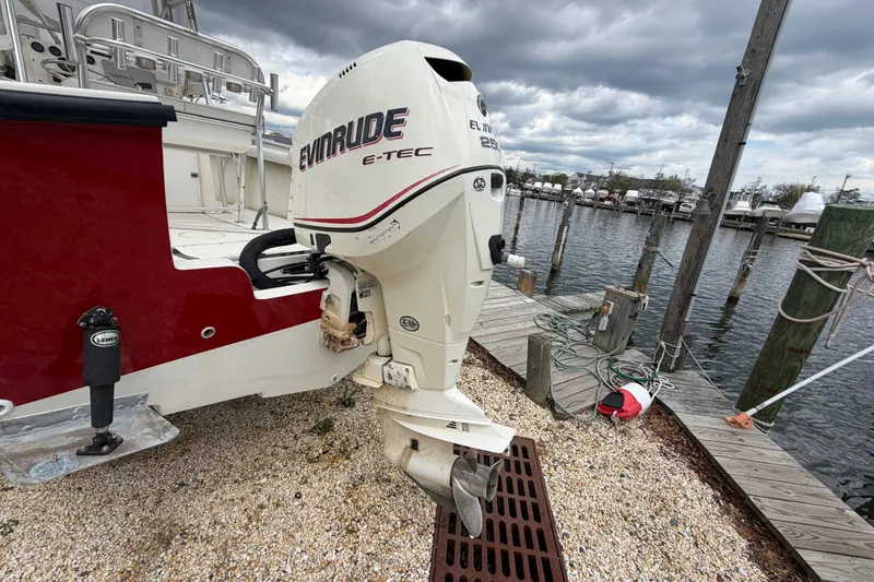 Slide: The Image of 1985 SeaCraft SC 23 Classic with Evinrude E-TEC engine docked by a marina. - 8