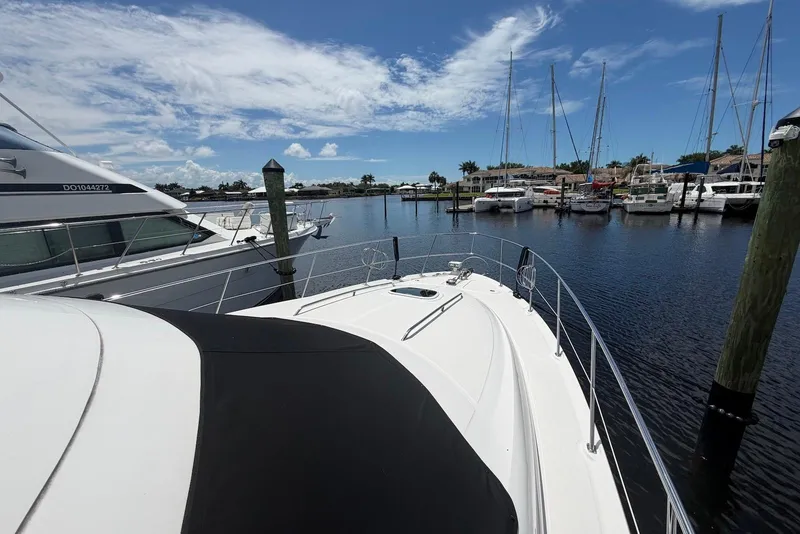 Slide: The Image of 2006 Sea Ray 44 Sedan Bridge yacht docked in a marina under a clear blue sky. - 11
