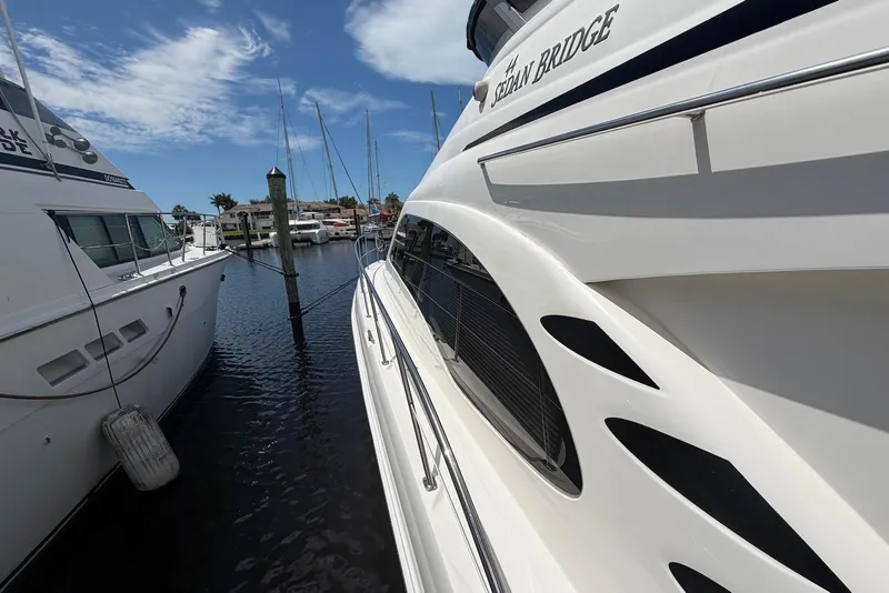 Slide: The Image of 2006 Sea Ray 44 Sedan Bridge yacht docked at marina under clear blue sky. - 14