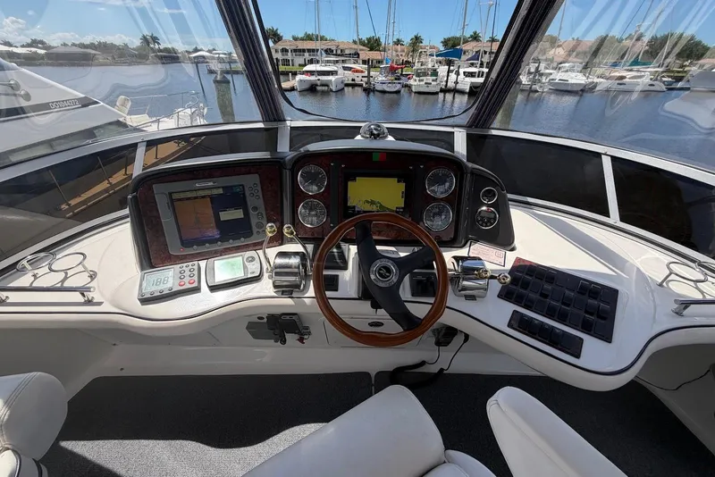 Slide: The Image of Helm of 2006 Sea Ray 44 Sedan Bridge with navigation equipment and marina view. - 16
