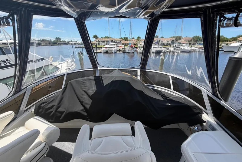 Slide: The Image of 2006 Sea Ray 44 Sedan Bridge helm view with marina backdrop. - 17