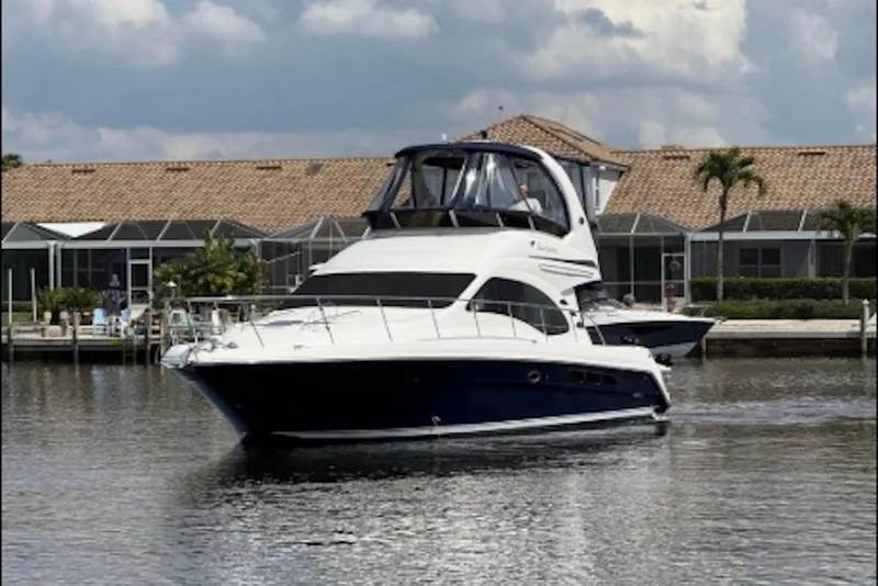 Slide: The Image of 2006 Sea Ray 44 Sedan Bridge yacht cruising on a calm waterway. - 2
