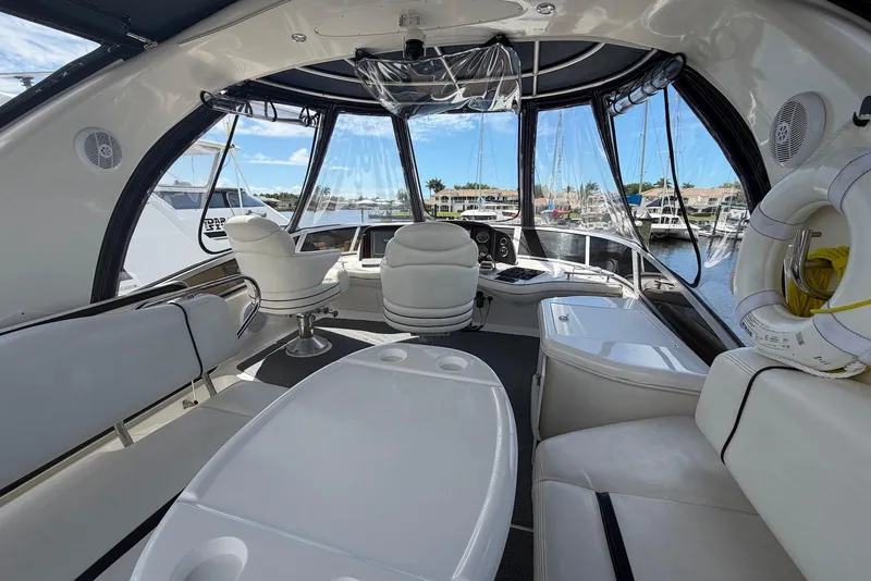 Slide: The Image of Interior view of 2006 Sea Ray 44 Sedan Bridge yacht with white seating and helm. - 23