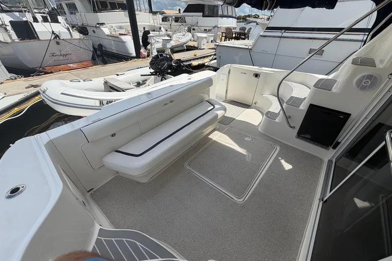 Slide: The Image of 2006 Sea Ray 44 Sedan Bridge yacht deck with seating, docked alongside other boats. - 25