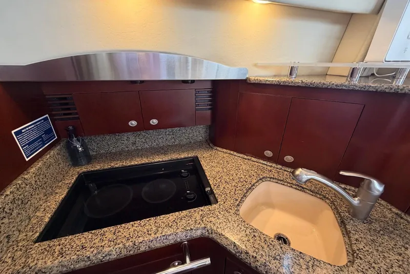 Slide: The Image of Luxurious kitchen area in a 2006 Sea Ray 44 Sedan Bridge yacht with granite countertops. - 36