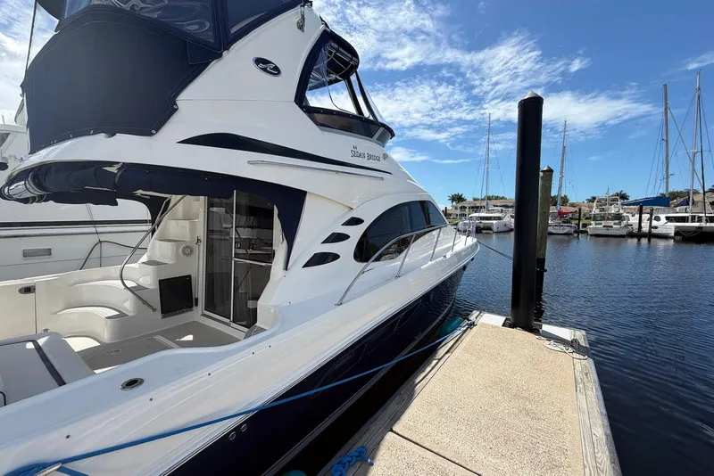 Slide: The Image of 2006 Sea Ray 44 Sedan Bridge yacht docked at marina under clear blue sky. - 5