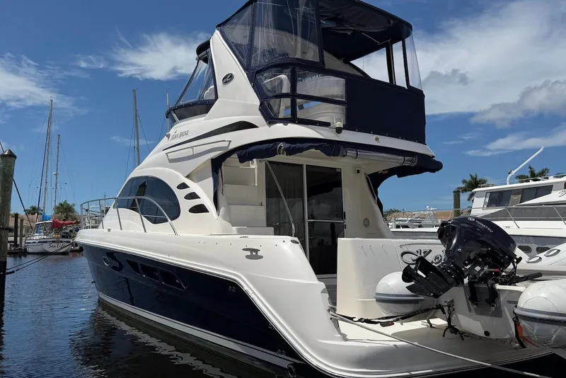 Slide: The Image of 2006 Sea Ray 44 Sedan Bridge yacht docked at marina under clear blue sky. - 6