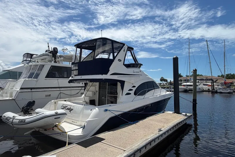 Slide: The Image of 2006 Sea Ray 44 Sedan Bridge yacht docked at marina under blue sky. - 8