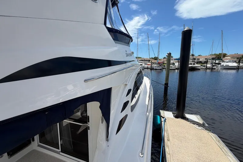 Slide: The Image of 2006 Sea Ray 44 Sedan Bridge yacht docked at marina under clear blue sky. - 9