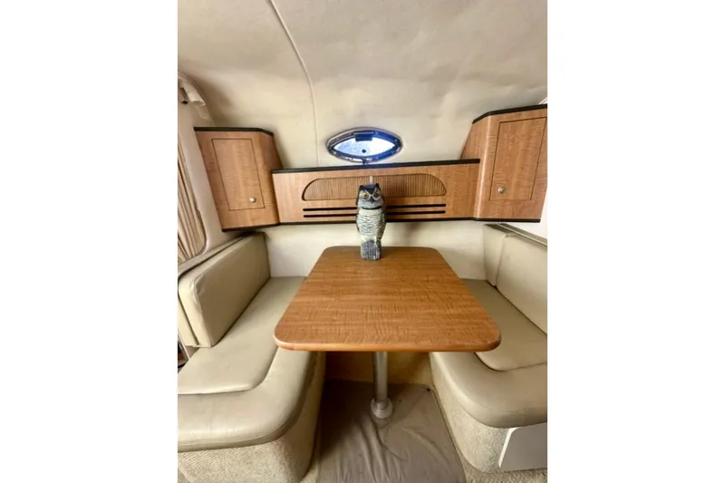 Slide: The Image of Interior of 2006 Sea Ray Sundancer 280 with wooden table and seating area. - 12