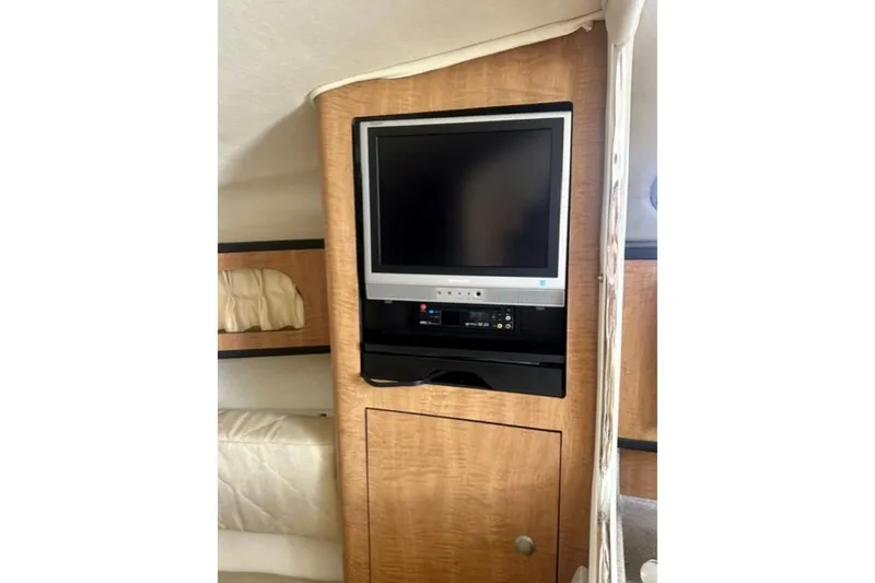 Slide: The Image of 2006 Sea Ray Sundancer 280 cabin interior with built-in TV and wood paneling. - 14