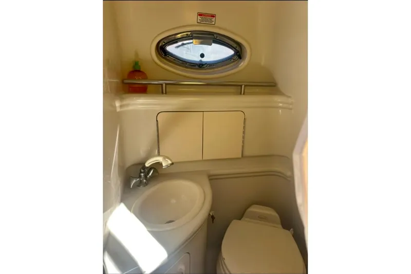 Slide: The Image of 2006 Sea Ray Sundancer 280 bathroom with sink, toilet, and porthole window. - 16