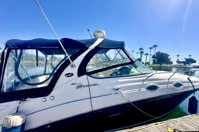 Slide: The Image of 2006 Sea Ray Sundancer 280 docked by a sunny waterfront with palm trees. - 2