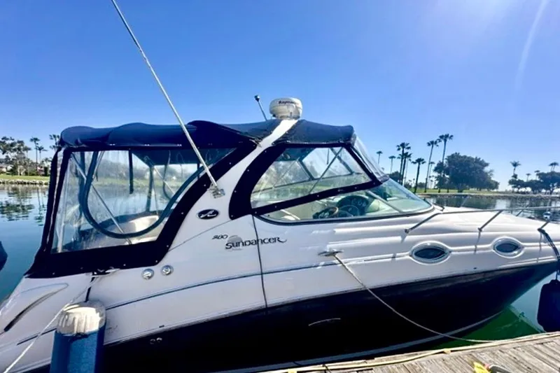 Slide: The Image of 2006 Sea Ray Sundancer 280 docked, featuring sleek design and clear canopy under blue sky. - 25