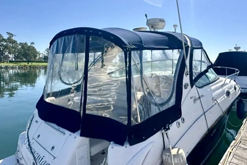 Slide: The Image of 2006 Sea Ray Sundancer 280 docked with clear canopy, calm water background. - 3
