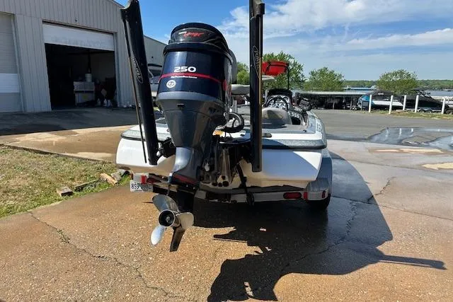 Slide: The Image of 2007 Skeeter ZX250 boat with powerful outboard motor, parked near a garage. - 6