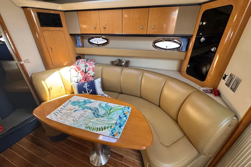 Slide: The Image of 2006 Chaparral Signature 350 yacht interior with beige seating and wooden table. - 34